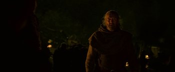 Movie still from “Outlaw King” (2018), directed by David Mackenzie – A man with a beard and a long beard is standing in the dark; Medium shot, Low angle