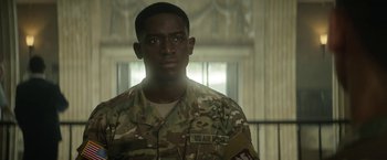 Movie still from “Outside the Wire” (2021), directed by Mikael Håfström – A man in a military uniform standing in front of a window; Close Up shot, Over the shoulder angle
