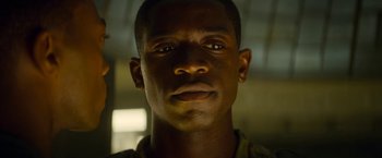 Movie still from “Outside the Wire” (2021), directed by Mikael Håfström – A man's face in the dark; Close Up shot, Low angle