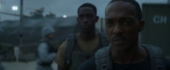 Movie still from “Outside the Wire” (2021), directed by Mikael Håfström – Two men are standing in the dark looking at the camera; Close Up shot, Over the shoulder angle