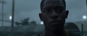 Movie still from “Outside the Wire” (2021), directed by Mikael Håfström – A man's face in the dark; Close Up shot, Low angle