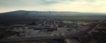 Movie still from “Outside the Wire” (2021), directed by Mikael Håfström – An aerial view of an industrial area in the middle of nowhere; Extreme Wide shot, High angle