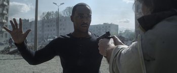 Movie still from “Outside the Wire” (2021), directed by Mikael Håfström – A man holding a gun pointed at another man; Medium shot, Over the shoulder angle