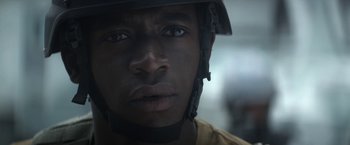 Movie still from “Outside the Wire” (2021), directed by Mikael Håfström – A person wearing a helmet; Close Up shot, Over the shoulder angle