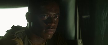 Movie still from “Outside the Wire” (2021), directed by Mikael Håfström – A man's face in the dark; Close Up shot, Low angle