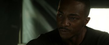 Movie still from “Outside the Wire” (2021), directed by Mikael Håfström – A man's face in a darkened room; Close Up shot, High angle