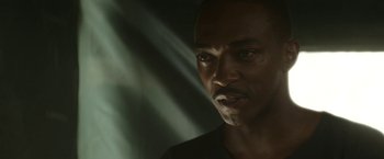 Movie still from “Outside the Wire” (2021), directed by Mikael Håfström – A man's face in the dark; Close Up shot, Low angle