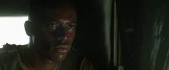 Movie still from “Outside the Wire” (2021), directed by Mikael Håfström – A man's face in the dark; Close Up shot, Low angle