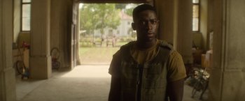 Movie still from “Outside the Wire” (2021), directed by Mikael Håfström – A man standing in front of an open door; Medium shot, Over the shoulder angle