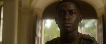 Movie still from “Outside the Wire” (2021), directed by Mikael Håfström – A man's face in front of a window; Close Up shot, Low angle