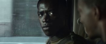 Movie still from “Outside the Wire” (2021), directed by Mikael Håfström – A person looking out of a window; Close Up shot, Over the shoulder angle