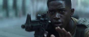 Movie still from “Outside the Wire” (2021), directed by Mikael Håfström – A person holding a gun; Close Up shot, Over the shoulder angle
