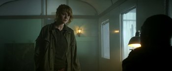 Movie still from “Outside the Wire” (2021), directed by Mikael Håfström – A woman standing in a dimly - lit room; Medium shot, Low angle