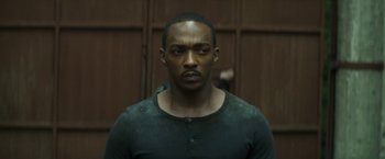 Movie still from “Outside the Wire” (2021), directed by Mikael Håfström – A man in a black shirt is standing in a room; Close Up shot, Low angle