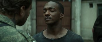 Movie still from “Outside the Wire” (2021), directed by Mikael Håfström – A man with his eyes wide open and his head tilted to the side; Close Up shot, Over the shoulder angle