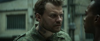 Movie still from “Outside the Wire” (2021), directed by Mikael Håfström – A person wearing a military uniform; Close Up shot, High angle