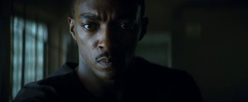 Movie still from “Outside the Wire” (2021), directed by Mikael Håfström – A man's face in the dark; Close Up shot, Low angle