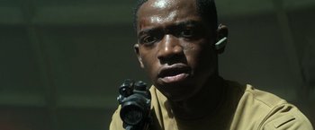 Movie still from “Outside the Wire” (2021), directed by Mikael Håfström – A person holding a camera; Close Up shot, Low angle