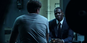 Movie still from “Ozark” (2017), created by Bill Dubuque – A man in a business suit talking to another man in a business suit; Medium shot, Over the shoulder angle