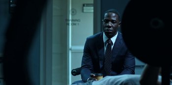 Movie still from “Ozark” (2017), created by Bill Dubuque – A man in a suit and tie holding a cup of coffee; Medium shot, Over the shoulder angle