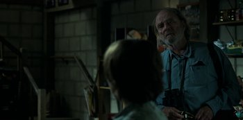 Movie still from “Ozark” (2017), created by Bill Dubuque – An older man with a beard is looking at a young woman; Medium shot, Over the shoulder angle