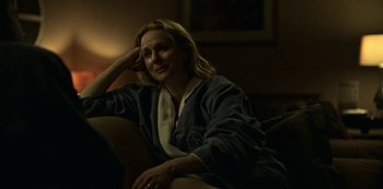 Movie still from “Ozark” (2017), created by Bill Dubuque – A woman sitting on a couch in a room; Medium shot, Over the shoulder angle