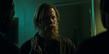 Movie still from “Ozark” (2017), created by Bill Dubuque – A man with a long beard holding a cell phone in his hand; Close Up shot, Over the shoulder angle