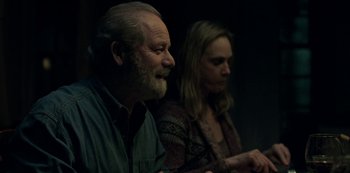 Movie still from “Ozark” (2017), created by Bill Dubuque – A man and a woman sitting next to each other in a dark room; Medium shot, Over the shoulder angle