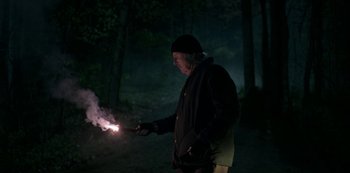 Movie still from “Ozark” (2017), created by Bill Dubuque – A man in a black jacket is holding a sparkler in the dark; Medium shot, Low angle