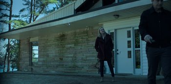 A woman standing in front of a brick building