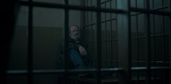 Movie still from “Ozark” (2017), created by Bill Dubuque – A man sitting on a bench in a jail cell; Medium shot, High angle