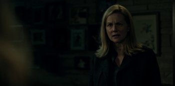 Movie still from “Ozark” (2017), created by Bill Dubuque – A woman standing in front of a wall with pictures on the wall; Close Up shot, Over the shoulder angle