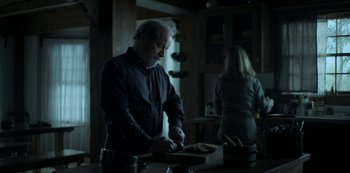 Movie still from “Ozark” (2017), created by Bill Dubuque – An older man and a young woman cutting food; Medium shot, Over the shoulder angle