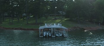 Movie still from “Ozark” (2017), created by Bill Dubuque – A boat dock with a boat on the water; Extreme Wide shot, High angle