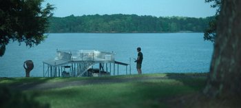 Movie still from “Ozark” (2017), created by Bill Dubuque – A man standing next to a dock near a body of water; Extreme Wide shot, Over the shoulder angle