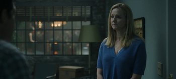 Movie still from “Ozark” (2017), created by Bill Dubuque – A woman standing in front of a window in a room; Medium shot, Over the shoulder angle