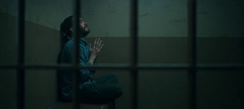 Movie still from “Ozark” (2017), created by Bill Dubuque – A man sitting in front of a window in a jail cell; Medium shot, High angle