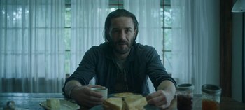 Movie still from “Ozark” (2017), created by Bill Dubuque – A man sitting at a table with a plate of food; Medium shot, Over the shoulder angle