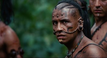 Movie still from “Apocalypto” (2006), directed by Mel Gibson – A man with tattoos on his face and neck; Close Up shot, Low angle