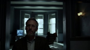 Movie still from “Mr. Robot” (2015), created by Sam Esmail – A man in a suit and glasses in a dark room; Close Up shot, Over the shoulder angle