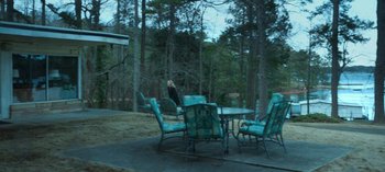 Movie still from “Ozark” (2017), created by Bill Dubuque – An outdoor table and chairs set up on a patio; Extreme Wide shot, High angle