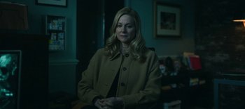 Movie still from “Ozark” (2017), created by Bill Dubuque – A woman standing in front of a wall in a dark room; Medium shot, Over the shoulder angle