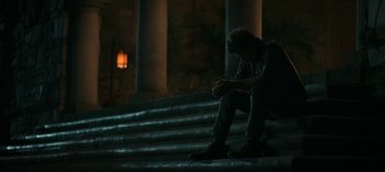 Movie still from “Ozark” (2017), created by Bill Dubuque – A man sitting on some steps in the dark; Wide shot, High angle