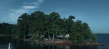 Movie still from “Ozark” (2017), created by Bill Dubuque – A house sitting on the side of a lake surrounded by trees; Extreme Wide shot, High angle