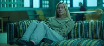 Movie still from “Ozark” (2017), created by Bill Dubuque – A woman sitting on top of a couch in a living room; Medium shot, High angle