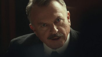 Movie still from “Peaky Blinders” (2013), created by Steven Knight – An older man wearing a suit and a tie; Close Up shot, Low angle