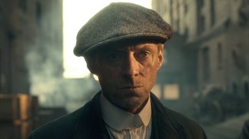 Movie still from “Peaky Blinders” (2013), created by Steven Knight – A person wearing a hat; Close Up shot, Low angle