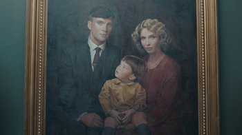 Movie still from “Peaky Blinders” (2013), created by Steven Knight – An oil painting of a man , woman , and a child; Close Up shot, Overhead angle