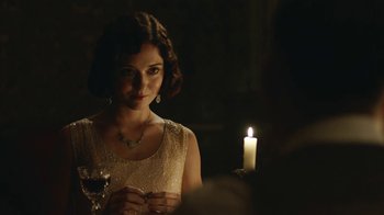 Movie still from “Peaky Blinders” (2013), created by Steven Knight – A beautiful woman standing in front of a lit candle; Close Up shot, Over the shoulder angle