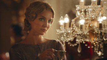 Movie still from “Peaky Blinders” (2013), created by Steven Knight – A beautiful woman holding a glass of wine in her hand; Close Up shot, Over the shoulder angle